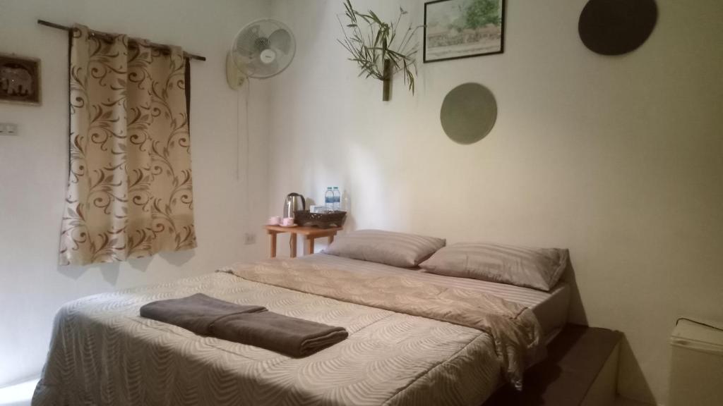 Una cama en un dormitorio con una manta. en navaa Bungalow, en Phra Ae beach