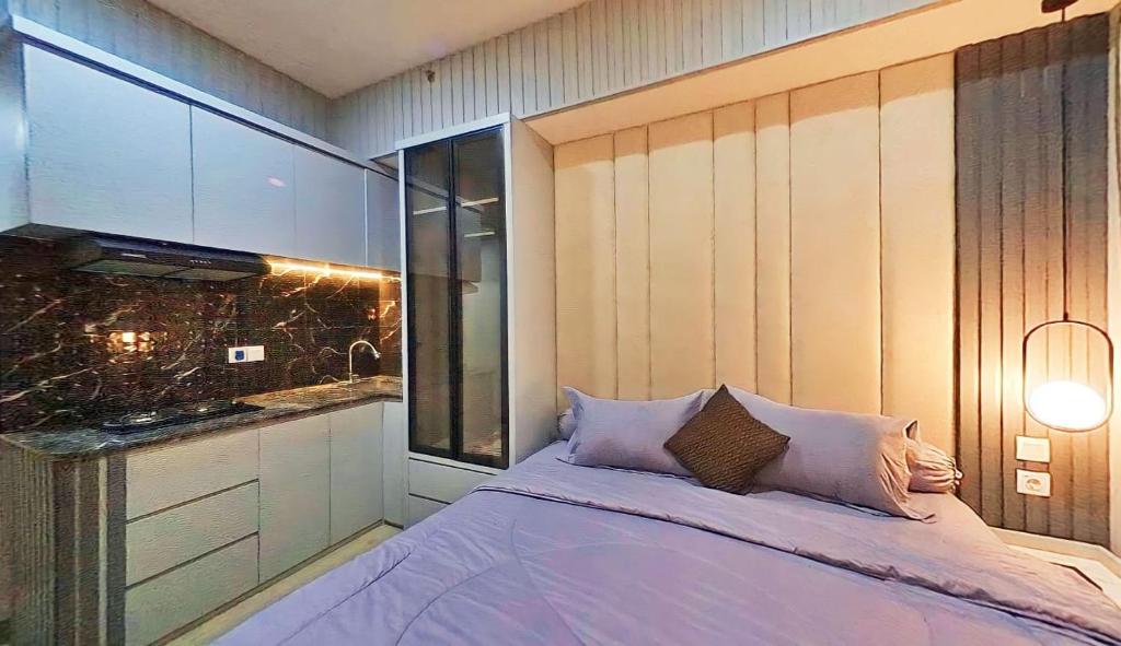 een slaapkamer met een groot bed en een wastafel bij Ayodhya Studio at Benson Tower in Lontar