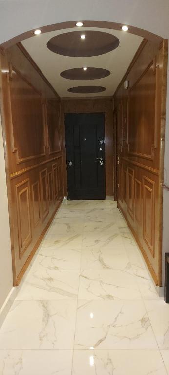 ein leeres Zimmer mit einer schwarzen Tür und einem weißen Fliesenboden in der Unterkunft Pyramids2 , Flat 309 ,2 Al Mansoureya Rd, Al Haram, Giza Governorate in Kairo