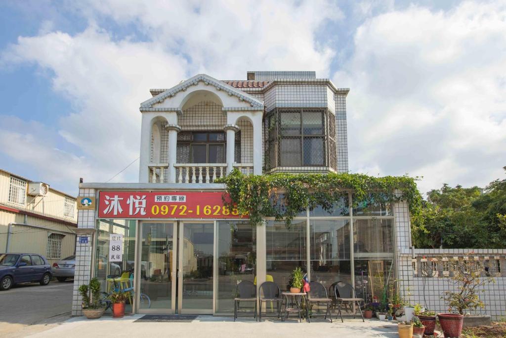 a building with a table and chairs in front of it at Huan Bei 88 Homestay in Jincheng
