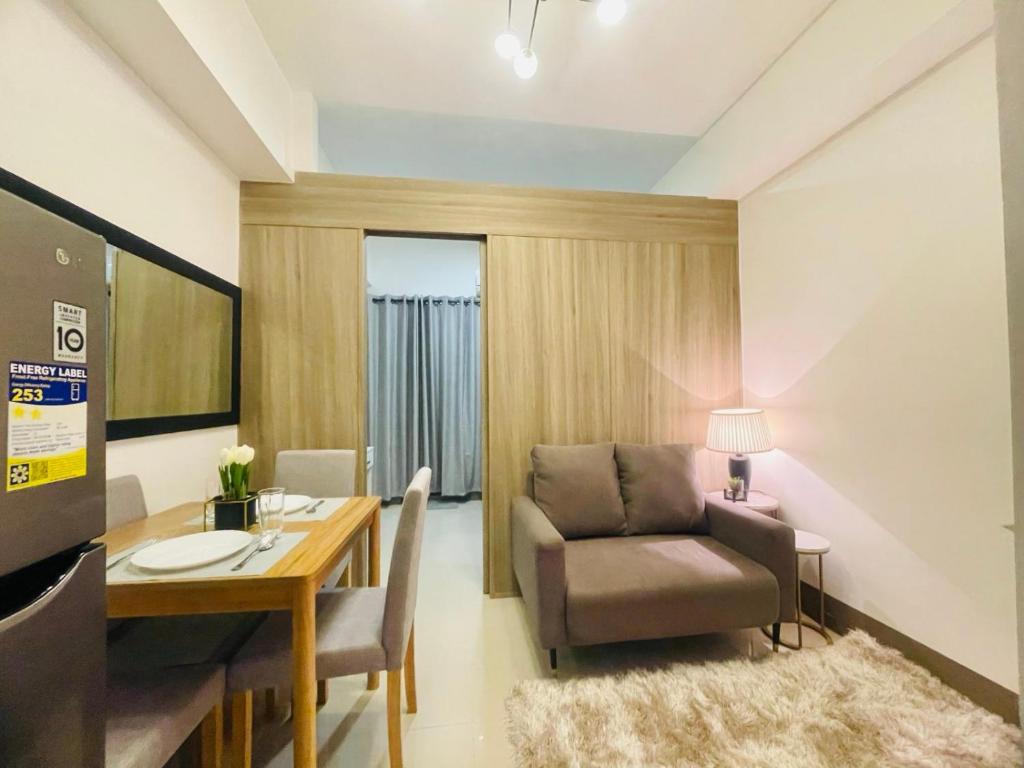 Una sala de estar con una mesa, una silla y un escritorio. en LoveFame 8M, en Manila