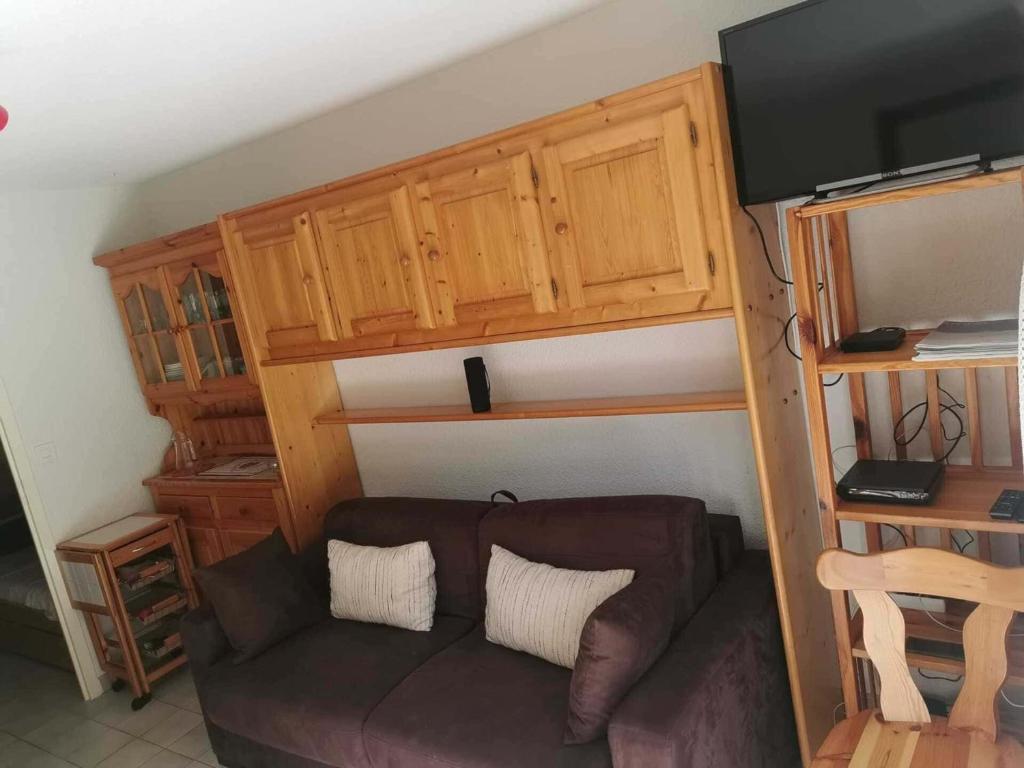 - un salon avec un canapé et des placards en bois dans l'établissement Studio lumineux avec terrasse, proche remontées mécaniques - Logement 3 personnes à Châtel - FR-1-676-180, à Châtel