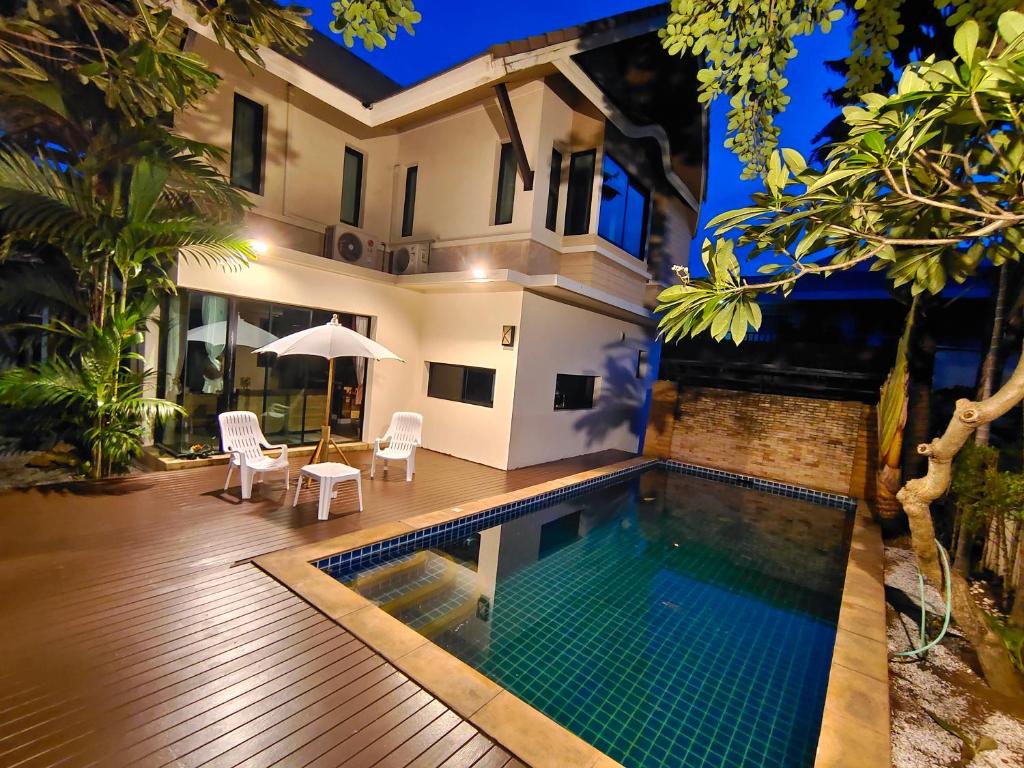 a villa with a swimming pool at night at Baan Natcha Villa in Pattaya Central