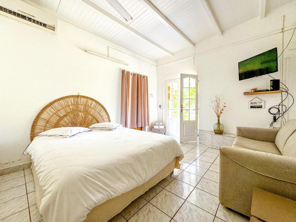 1 dormitorio con 1 cama grande y 1 sofá en Gîte Hibiscus Destrellan, en Baie-Mahault