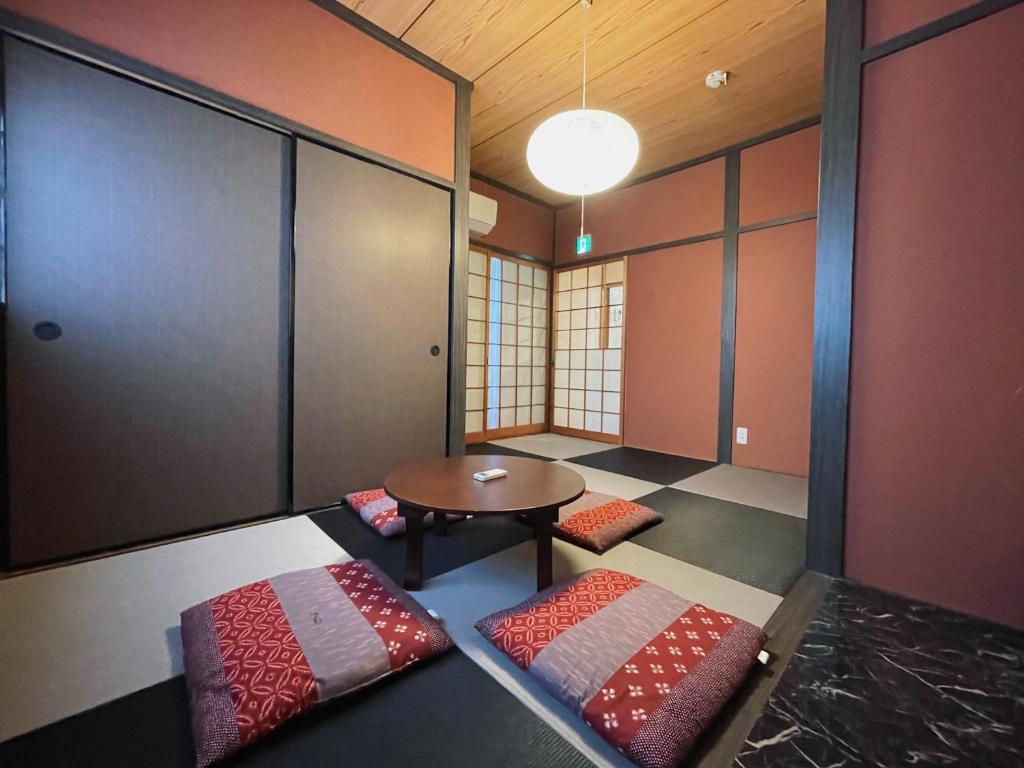 a room with a table and two pillows on the floor at East Shin-Osaka Hotel Apartment in Osaka