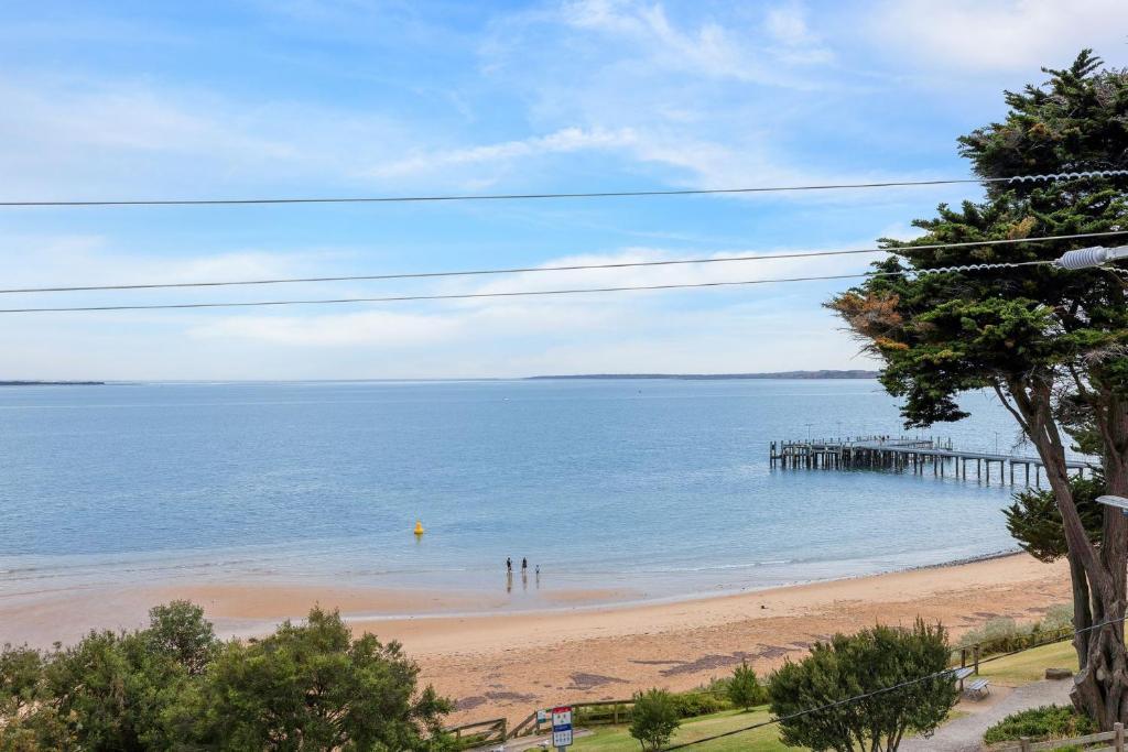 a view of a beach with a pier at Beachfront Bliss - shared indoor pool & spa in Cowes