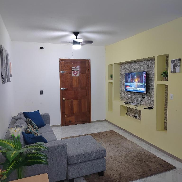 a living room with a couch and a tv at Departamento Familiar Escorpións in Tuxtla Gutiérrez