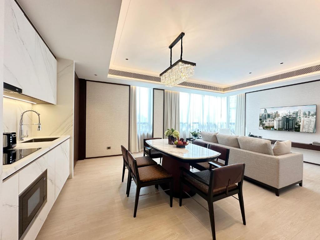 A spacious suite living area with a dining table, sofa, and full kitchenette.
