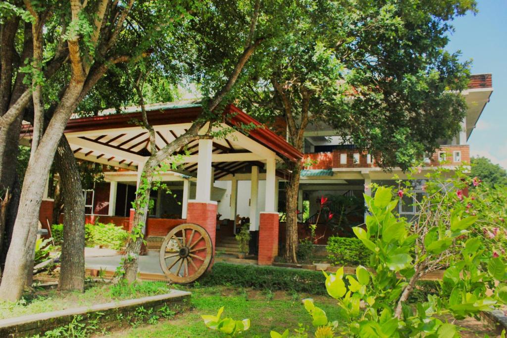 a house with a wagon in front of it at Green Hut Hotel & Restaurant with Unique View Point in Sigiriya