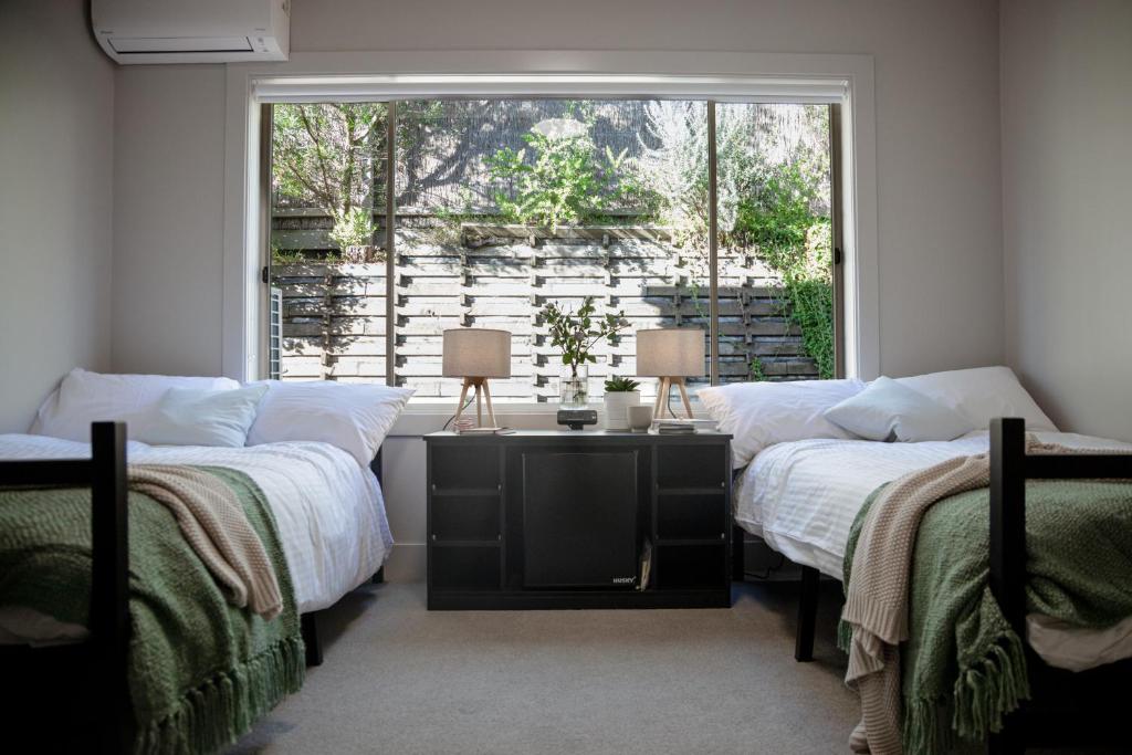 two beds in a room with a window at Sorrento Lodge in Sorrento