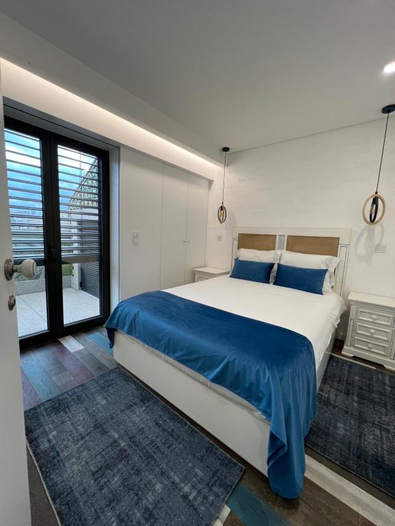 ein Schlafzimmer mit einem großen Bett mit blauen Kissen in der Unterkunft The Convo Porto Apartments in Porto