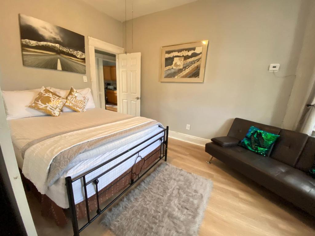 a bedroom with a bed and a couch at Charming and cozy apartment in New Jersey close to all the fun 10 minutes to NYC in West New York