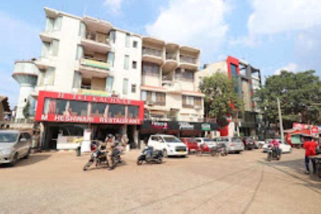 ruchliwa ulica miejska z samochodami i osobami na motocyklach w obiekcie Hotel Pandav,Pachmarhi w mieście Pachmarhi