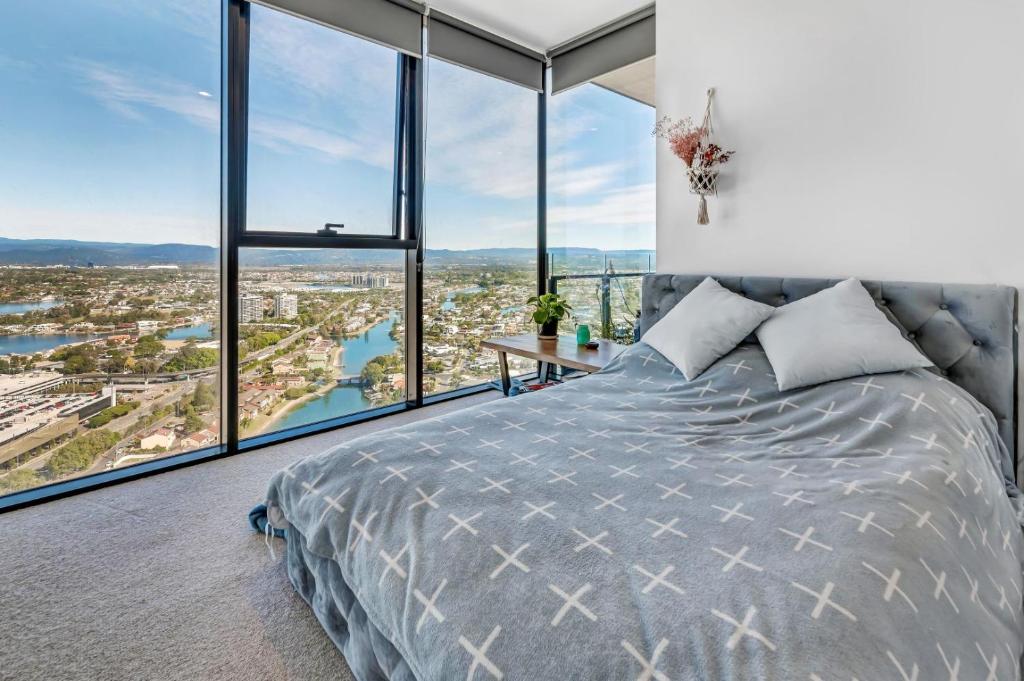 a bedroom with a large bed and large windows at Casino Residences 1 & 2 Bedroom Apartment in Gold Coast