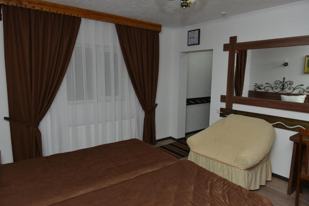 1 dormitorio con cama, espejo y ventana en Pensiunea Butoias Glodeni, en Glodeni