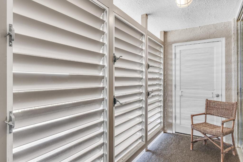 a room with a closet with a door and a chair at Magnolia House 507 At Destin Pointe Resort in Destin