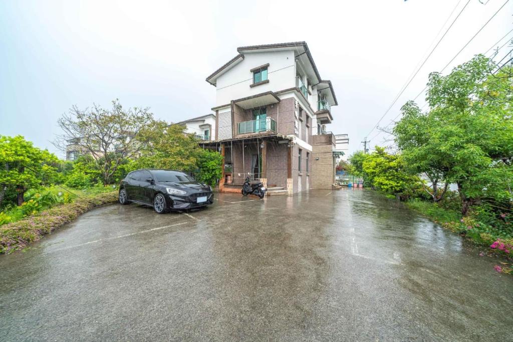 a car parked in front of a house on a flooded street at Yilan My House Homestay B&amp;B in Dayin