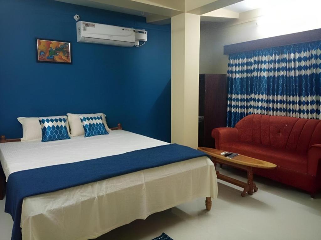 een slaapkamer met een bed en een rode bank bij Signature Stay in Port Blair