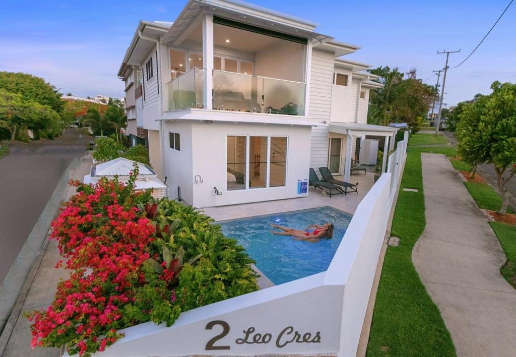 a person swimming in a swimming pool in a house at LEO2-SOPHISTICATED, BEACH HOLIDAY HOME in Alexandra Headland