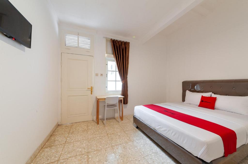 a bedroom with a large bed and a window at RedDoorz @ Kemang Dalam in Jakarta