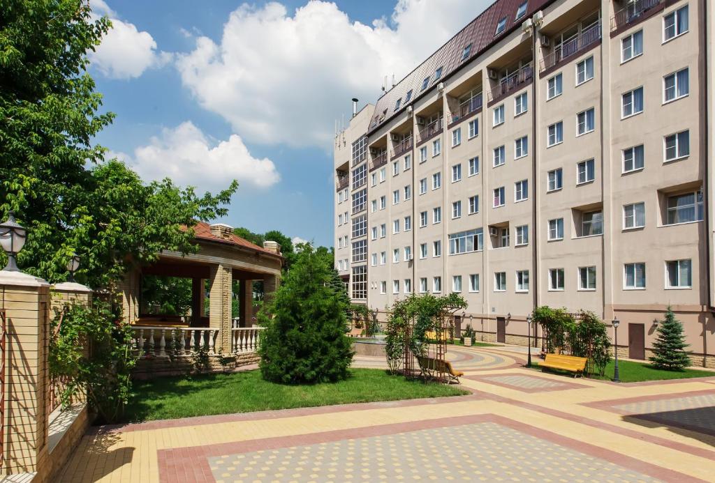 a large white building with a park in front of it at Park Hotel Nadezhda in Rostov on Don