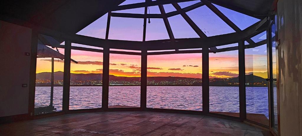 a room with a large window with a view of the water at Titicaca Halso Los uros in Puno