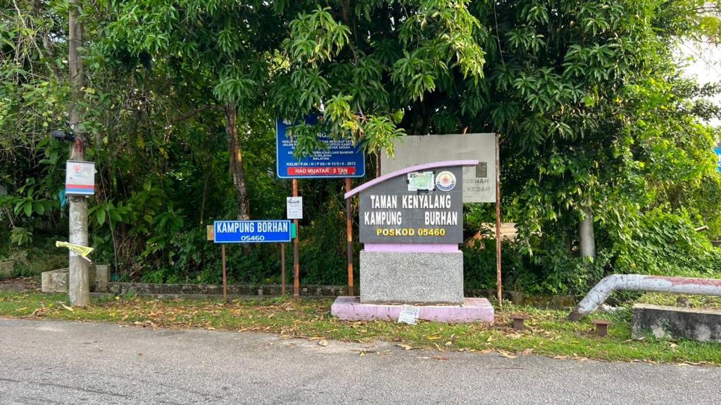a sign on the side of a road with signs at Asmar's Homestay Alor Setar in Alor Setar