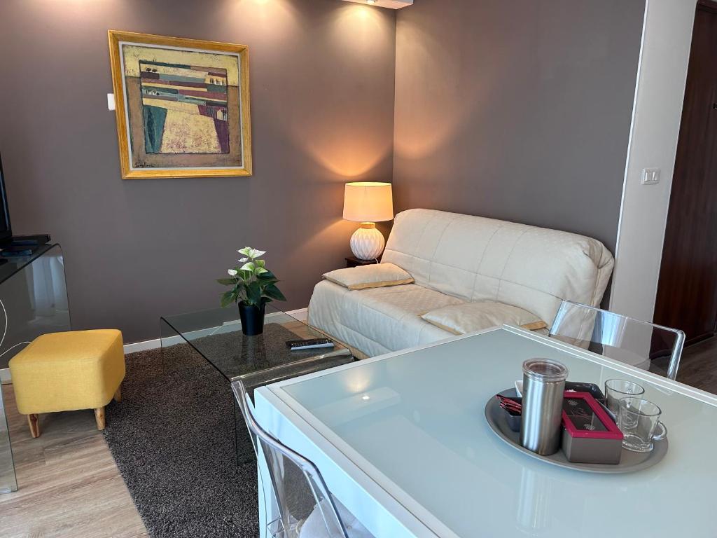 sala de estar con sofá y mesa en Front de mer- Appartement standing 1 chambre en Calais