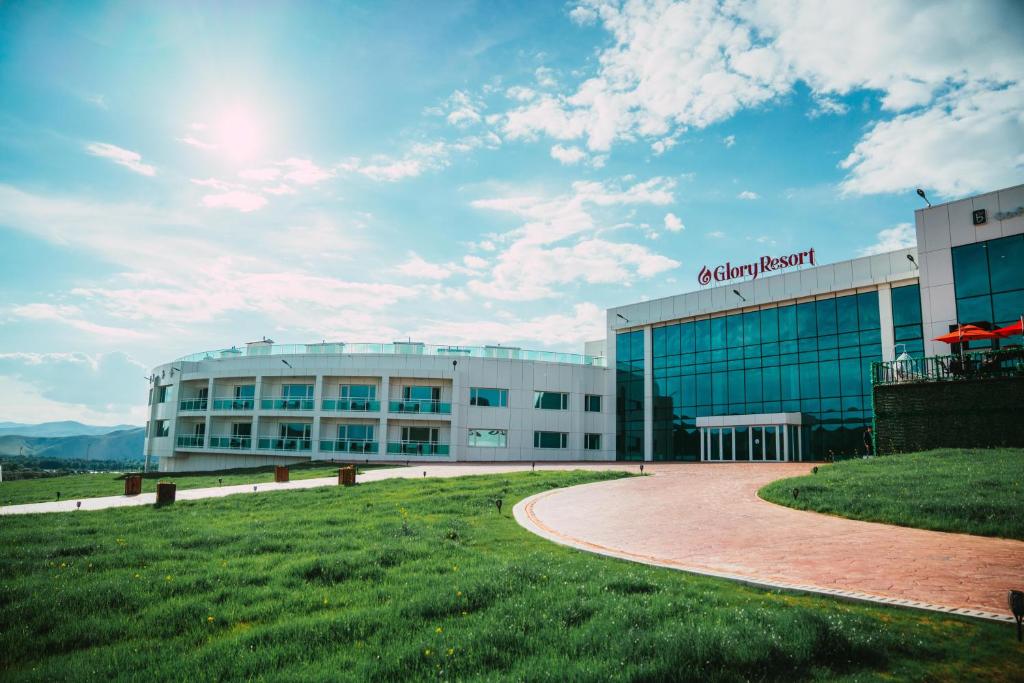 um grande edifício com um campo de relva em frente em Glory Resort Mongolia em Nalayh