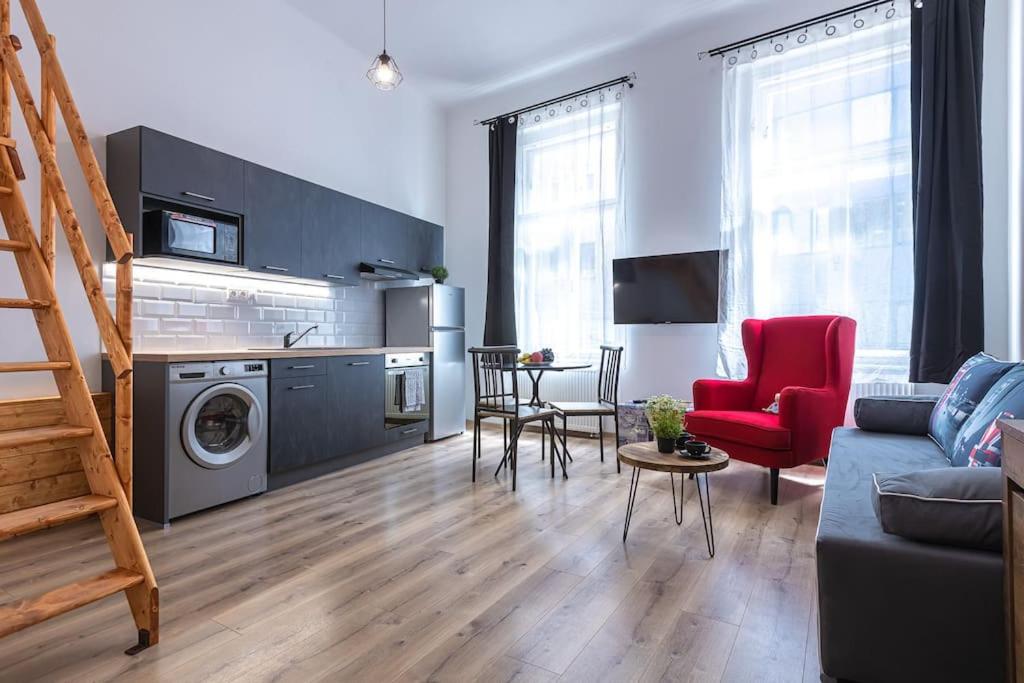 a living room with a couch and a table and a kitchen at CHARLIE - modern centrally located downtown studio in Bratislava