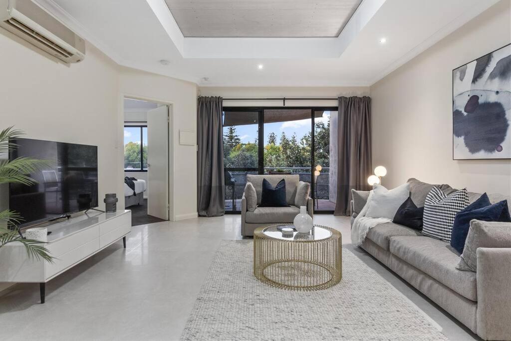 a living room with a couch and a tv at Luxury Retreat in the Heart of Subiaco in Perth