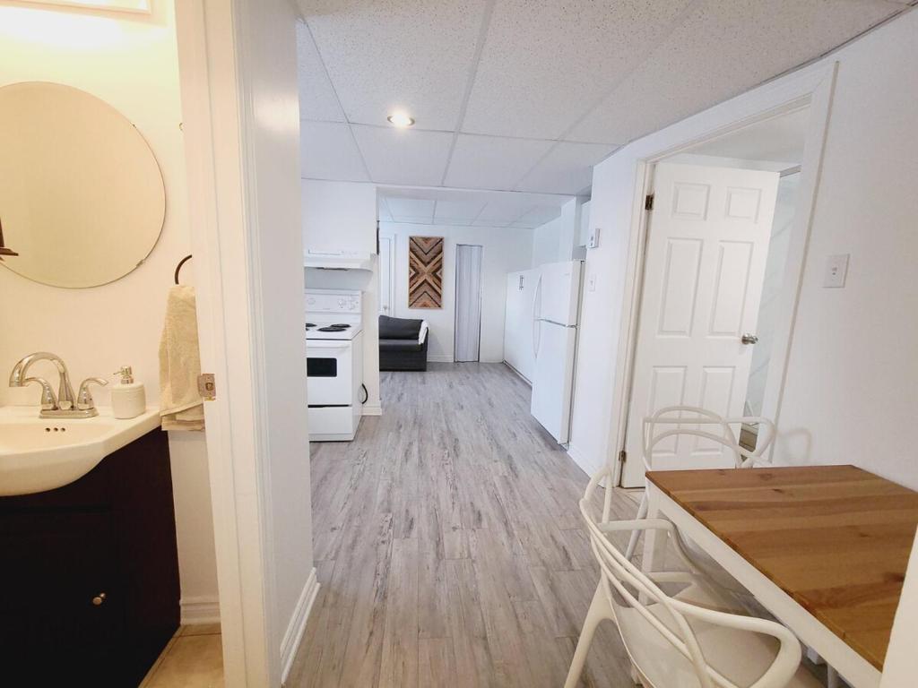 a kitchen and dining room with a sink and a table at Cozy 1BR in Vieux-Longueuil +parking 14min Downtown in Longueuil