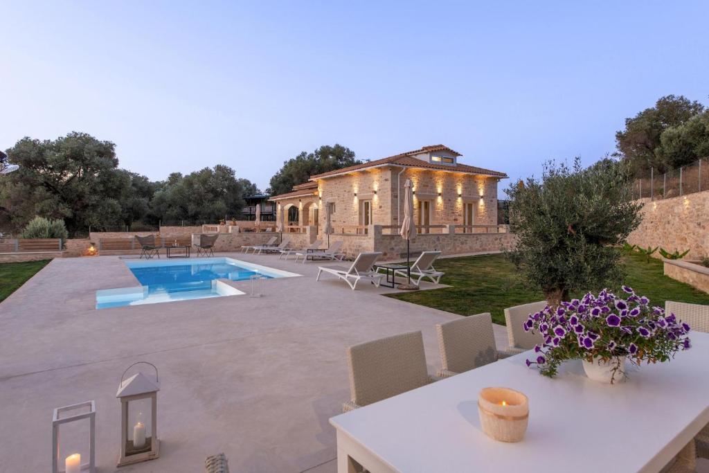 a villa with a swimming pool and a house at Villa Niragia with Magnificent view in Astérion