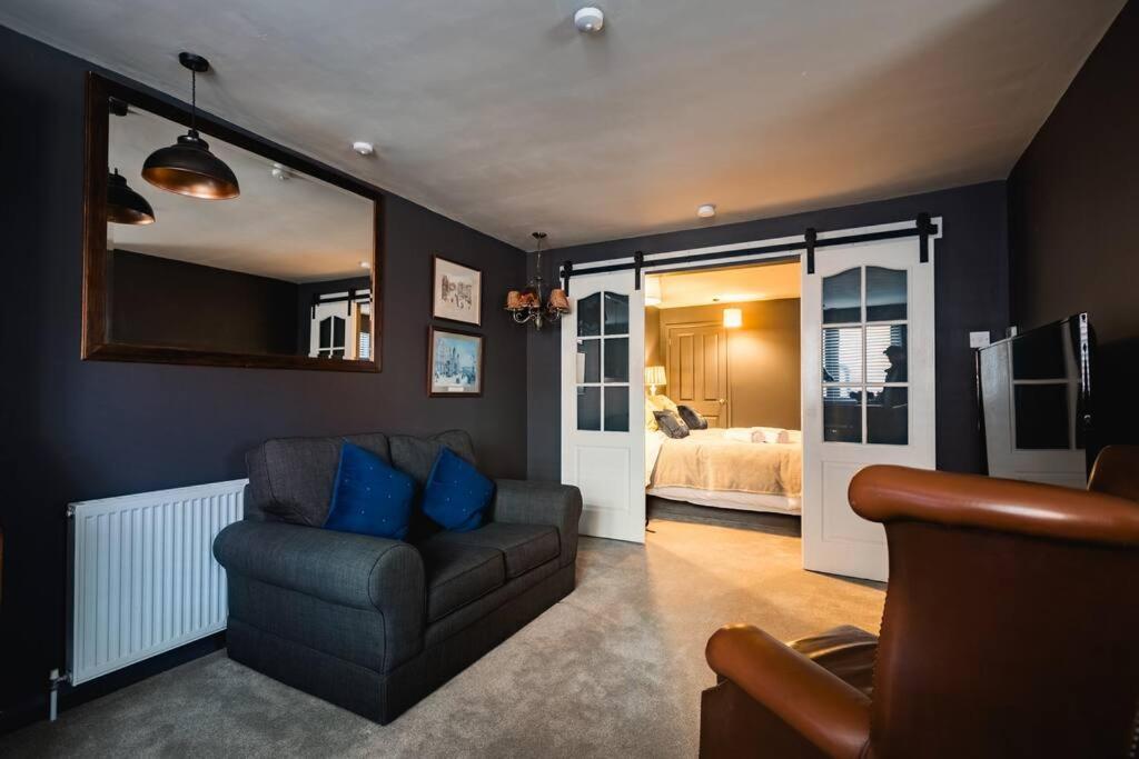 sala de estar con sofá y dormitorio en Hullidays》Old Town Luxury Cavern en Hull