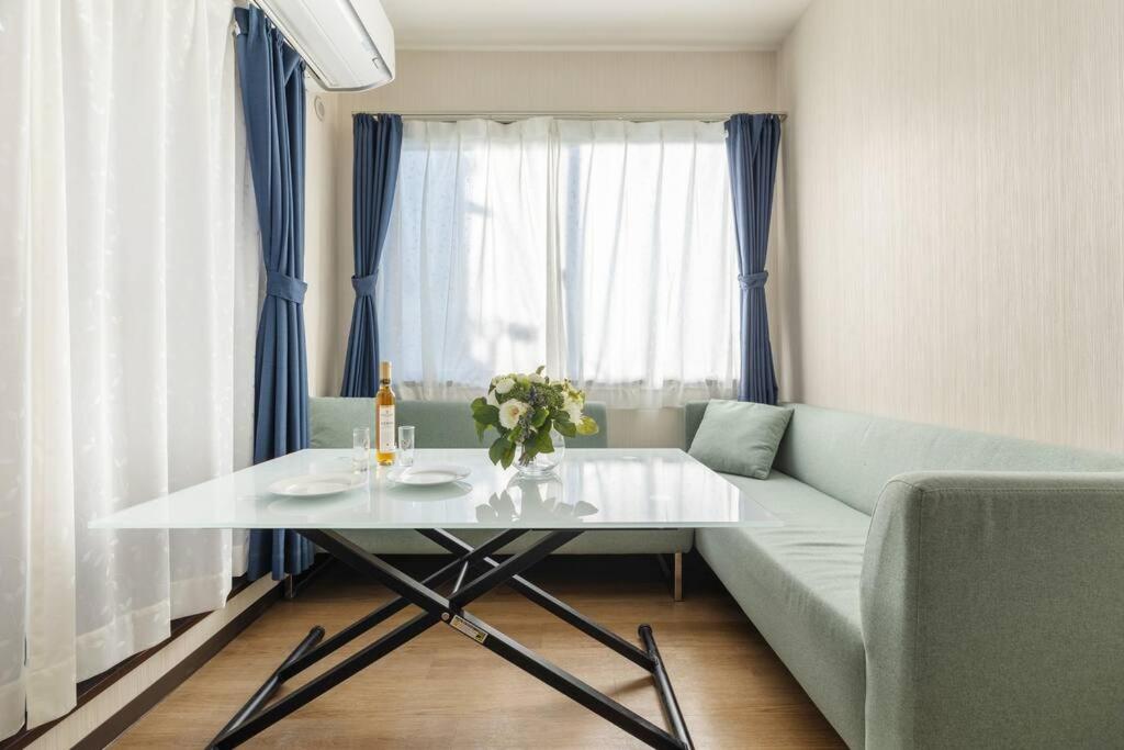 sala de estar con mesa blanca y sofá en Bright Modern Airbnb in Tokyo's Northern District, en Tokio