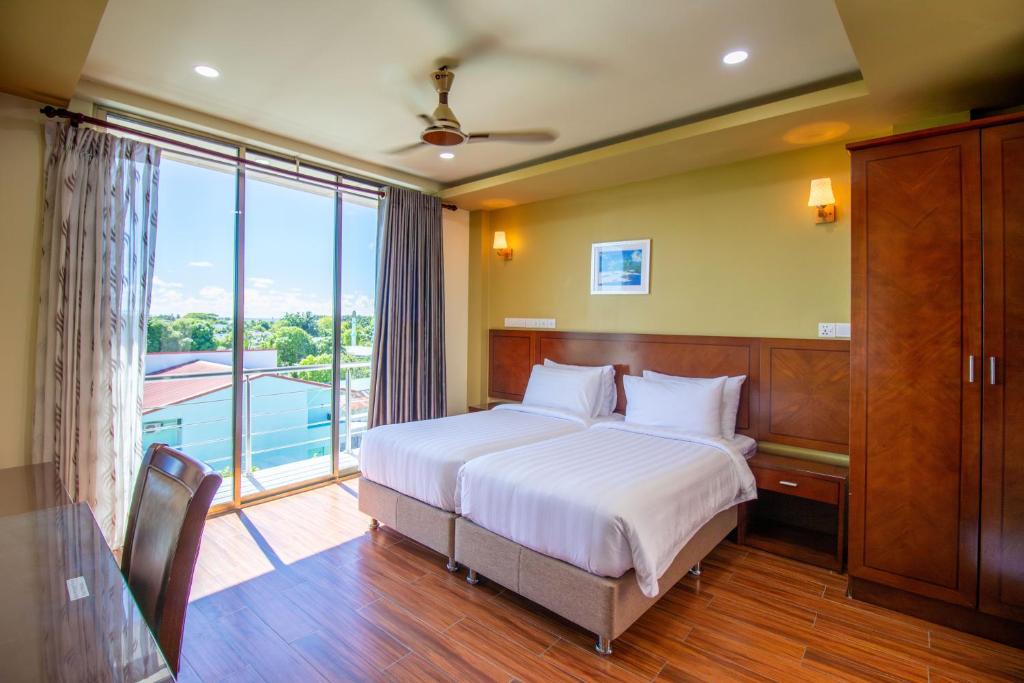 KudahuvadhooにあるBlue Wave Hotel Maldives for SURF, FISHING and Beachのベッドルーム1室(ベッド1台、大きな窓付)