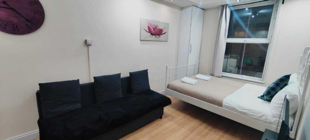 - une petite chambre avec un canapé et une fenêtre dans l'établissement Kings City Centre Apartments, à Londres