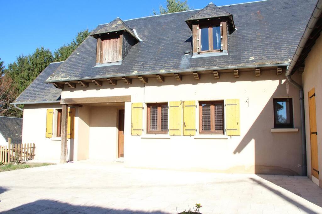 a white house with yellow doors and a driveway at Maison in Saint-Priest-de-Gimel