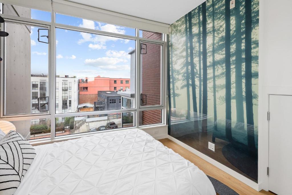 um quarto com uma cama e uma grande janela em Iconic Downtown Living! 1bedroom, Gym, Rooftop Patio. em Victoria