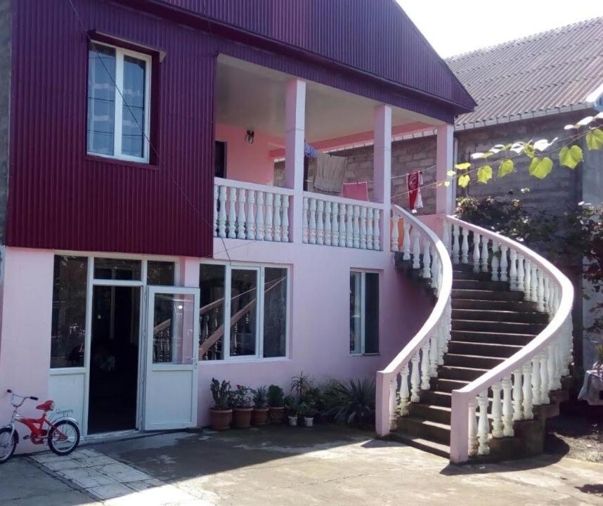 a pink and white house with a staircase at Gia Home in K'obulet'i