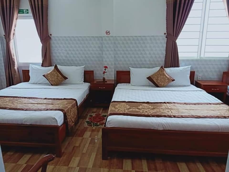 Habitación de hotel con 2 camas y ventana en Sơn Tùng Motel, en Ấp Trà Kha