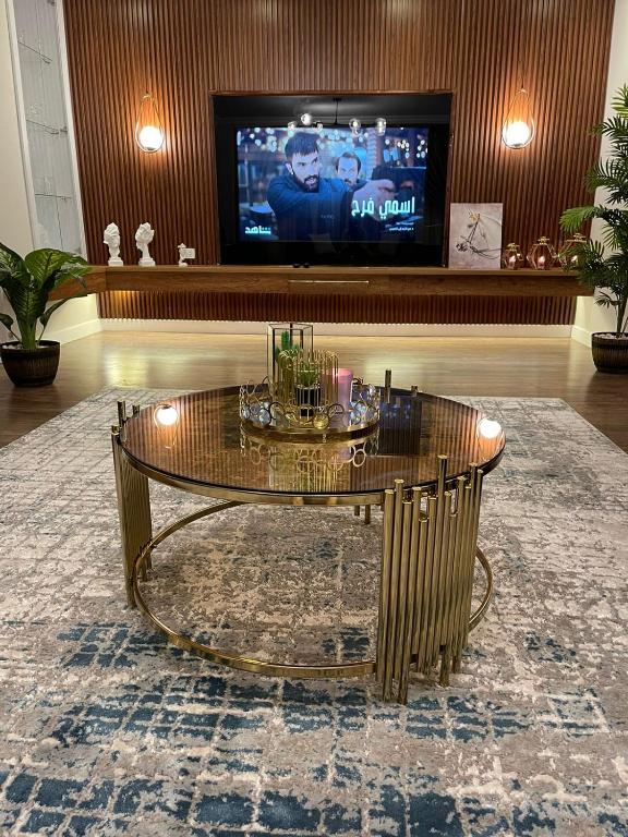 a living room with a coffee table and a tv at شقة فندقيه معقمه للإجار اليومي او الشهري in Cairo