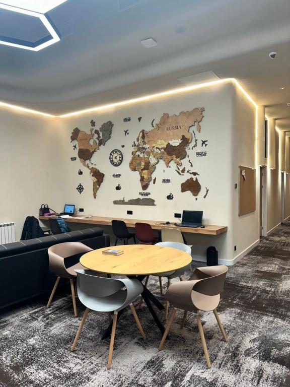 a meeting room with two tables and a map on the wall at AQ Capsule Hotel in Almaty