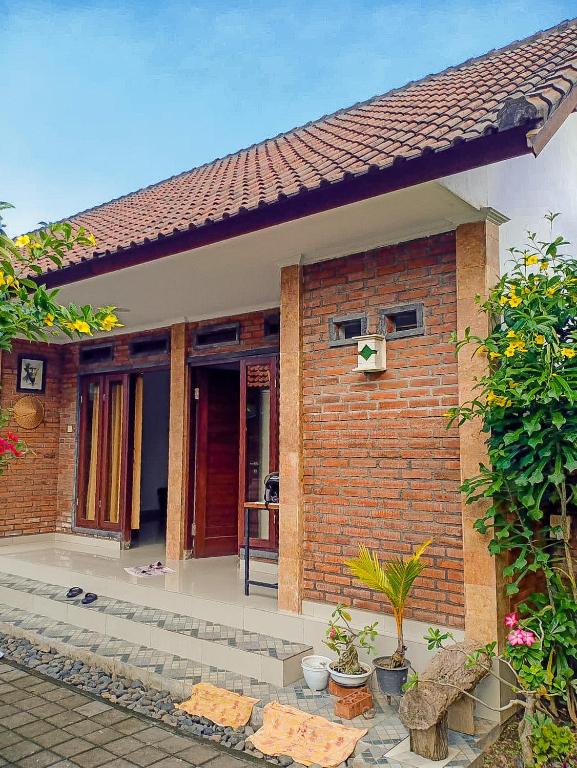 a brick house with a door with a cross on it at Pondok Selip Guesthouse in Krambitan
