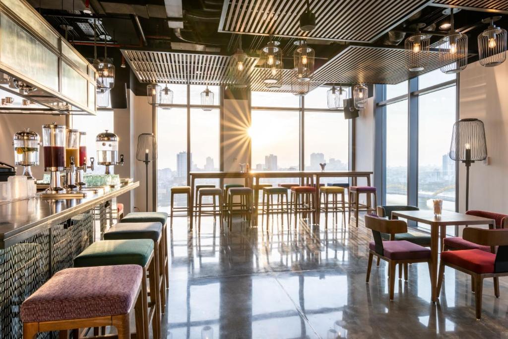 峴港的住宿－Wink Hotel Danang Centre - 24hrs stay，餐厅设有桌椅和大窗户。