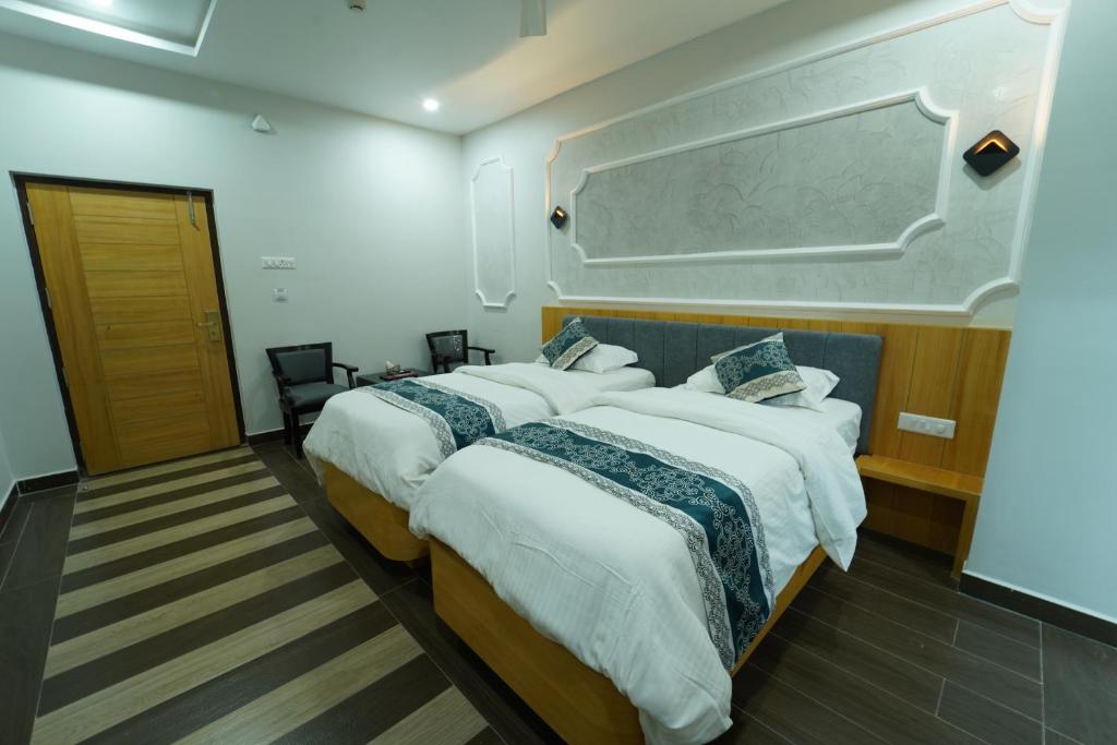 Habitación de hotel con 2 camas y una pizarra en la pared en Dvr Mansion en Kurnool