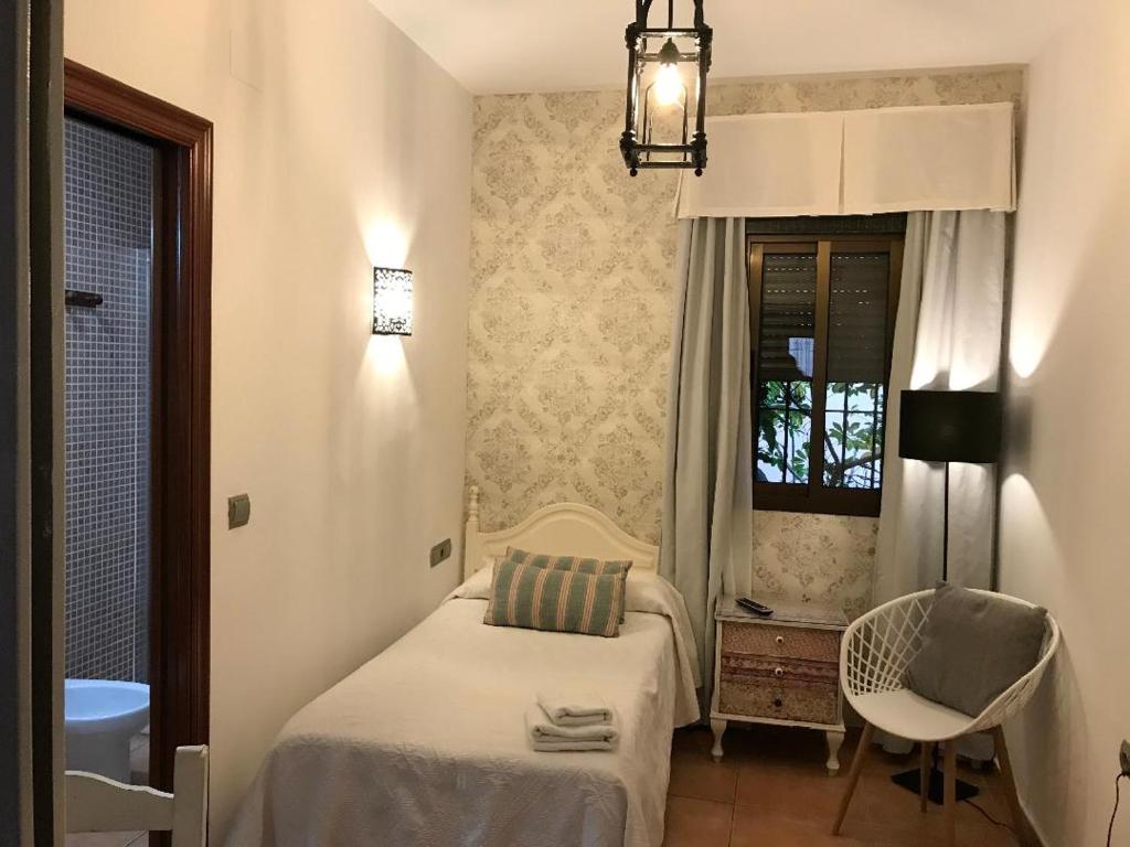 a small bedroom with a bed and a chair at Macavi in Rota