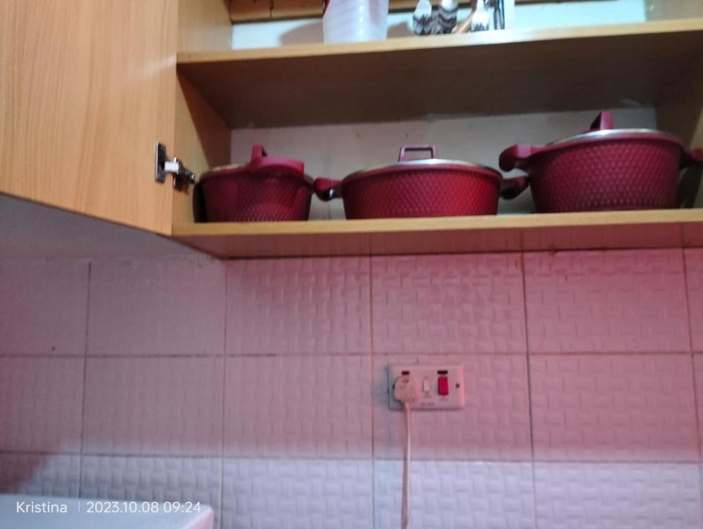 a kitchen with pots and pans on a shelf at Christie's apartments Buruburu in Nairobi