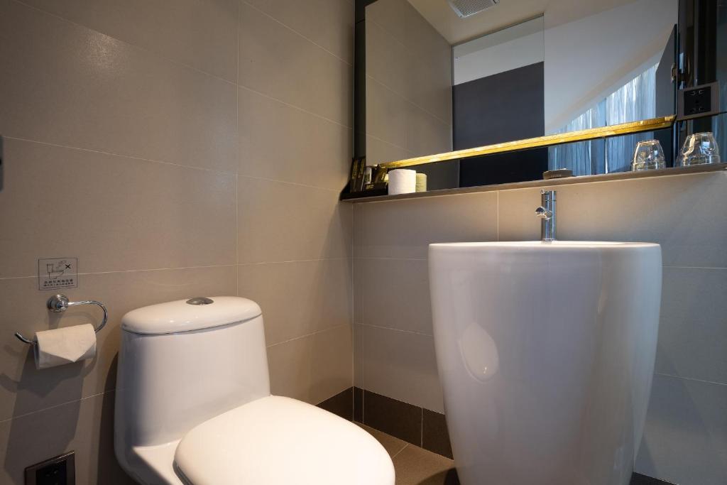 a bathroom with a white toilet and a sink at CHECK inn Taipei Xinyi in Taipei