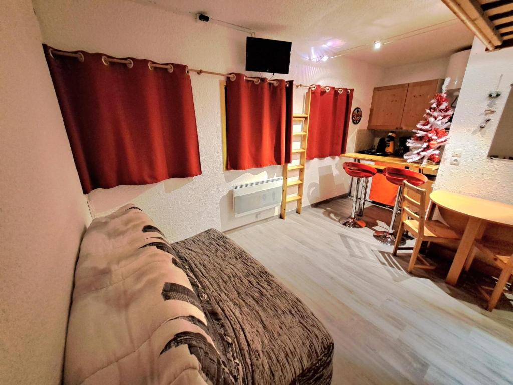um quarto com uma cama e uma cozinha com uma árvore de Natal em STUDIO CHALEUREUX aux pieds des pistes de ski des Glovettes em Villard-de-Lans